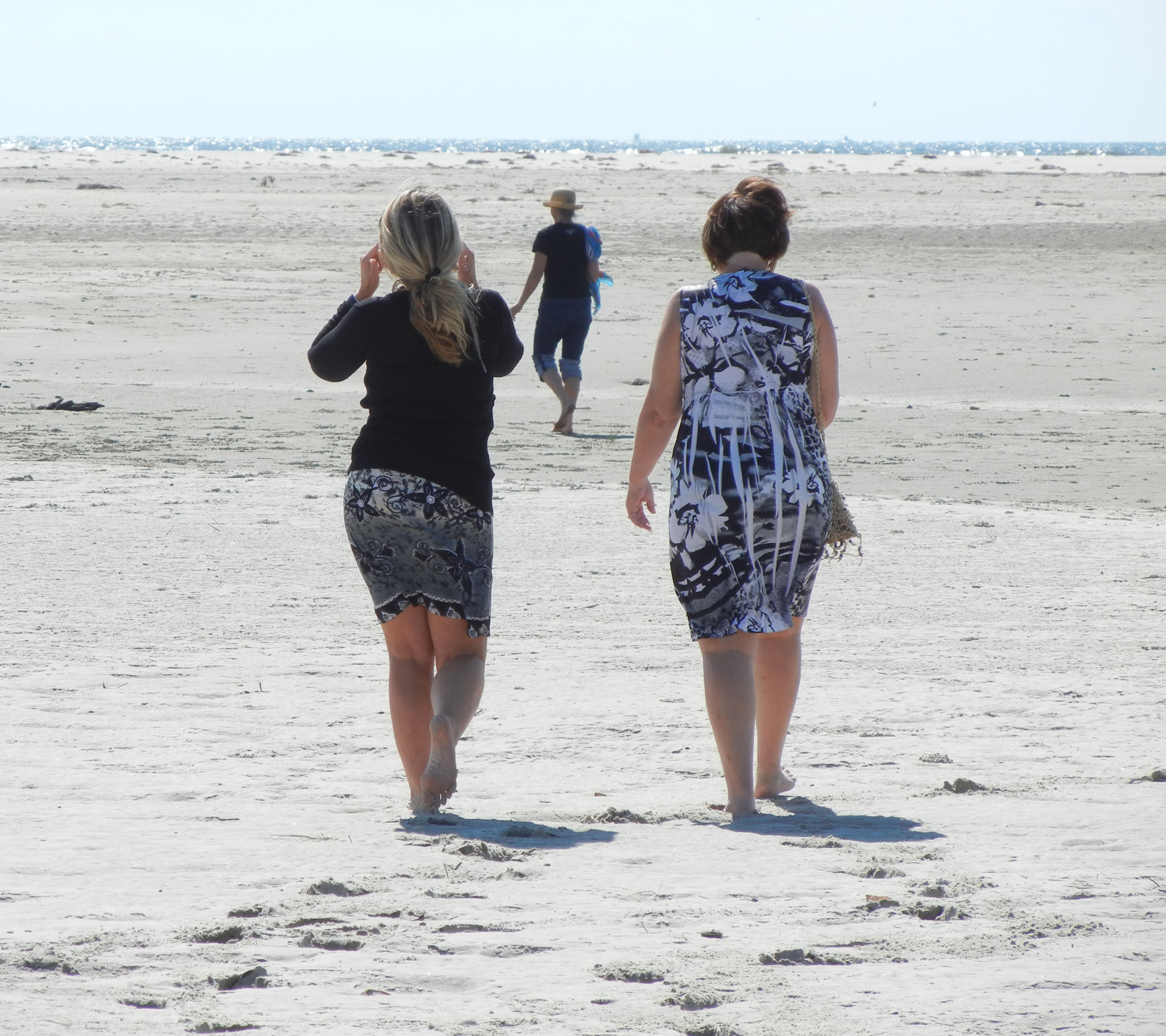 trio walking away beach